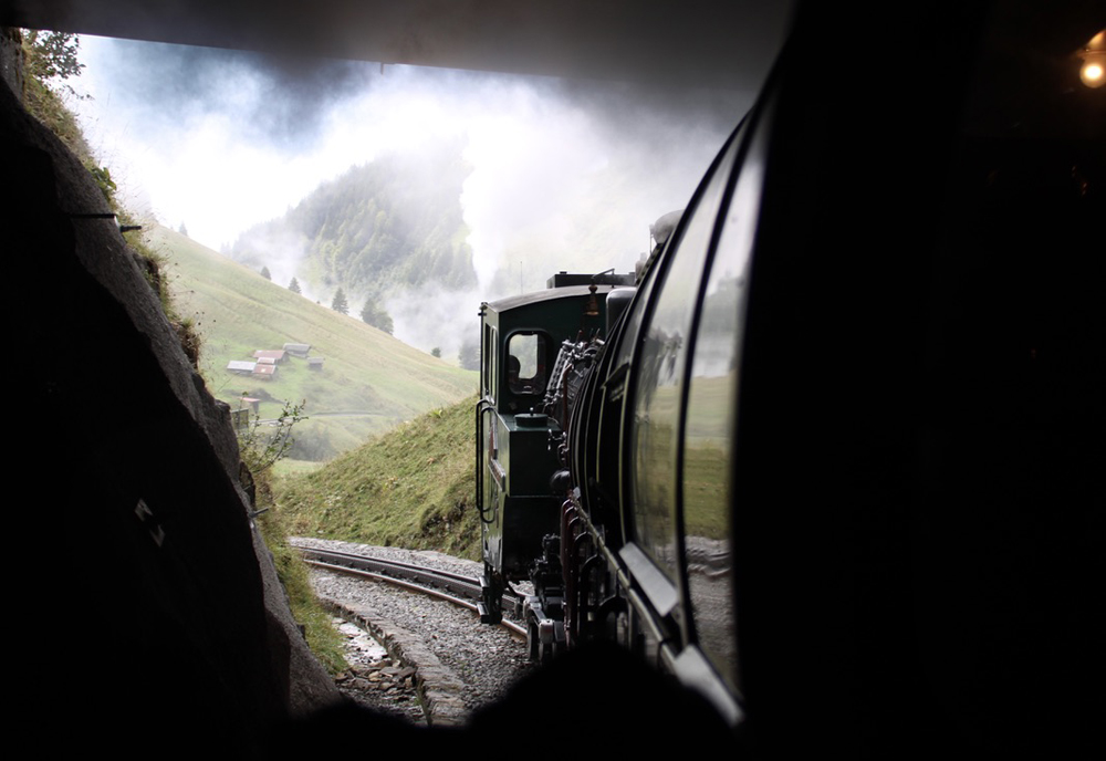 Steam locomotive exits tunnel as seen from train