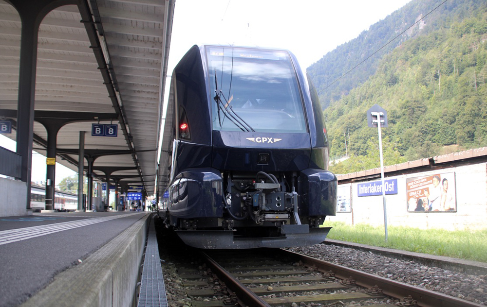 Blue passenger train with modern streamline design at station