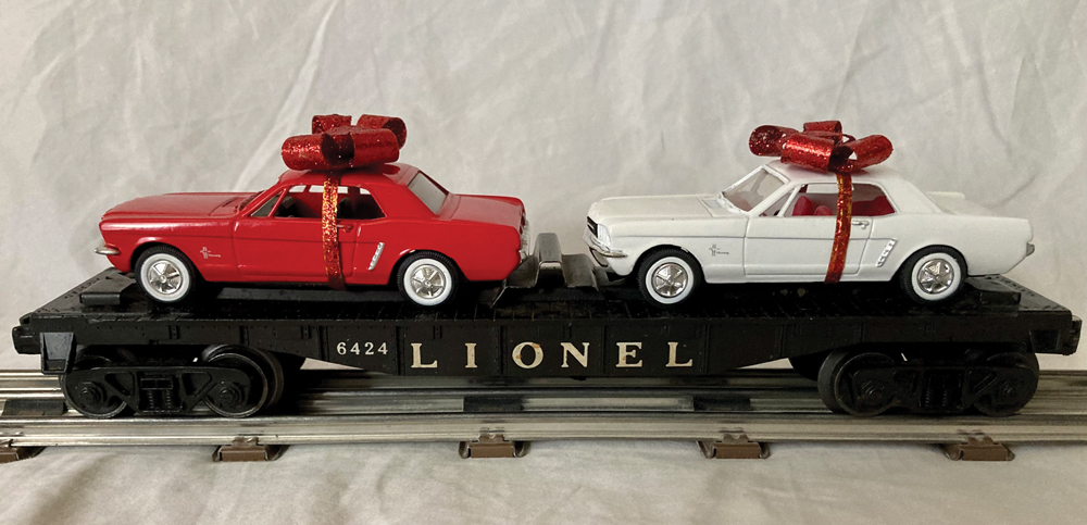 two model cars with bows on a flatcar