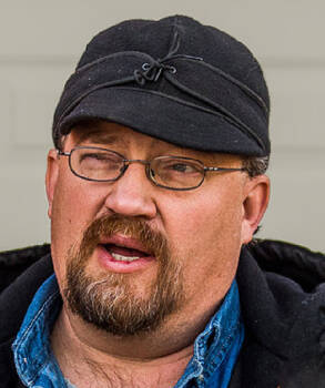 Man in black Cromier hat.