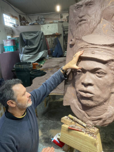 Artist sculpting a face in clay