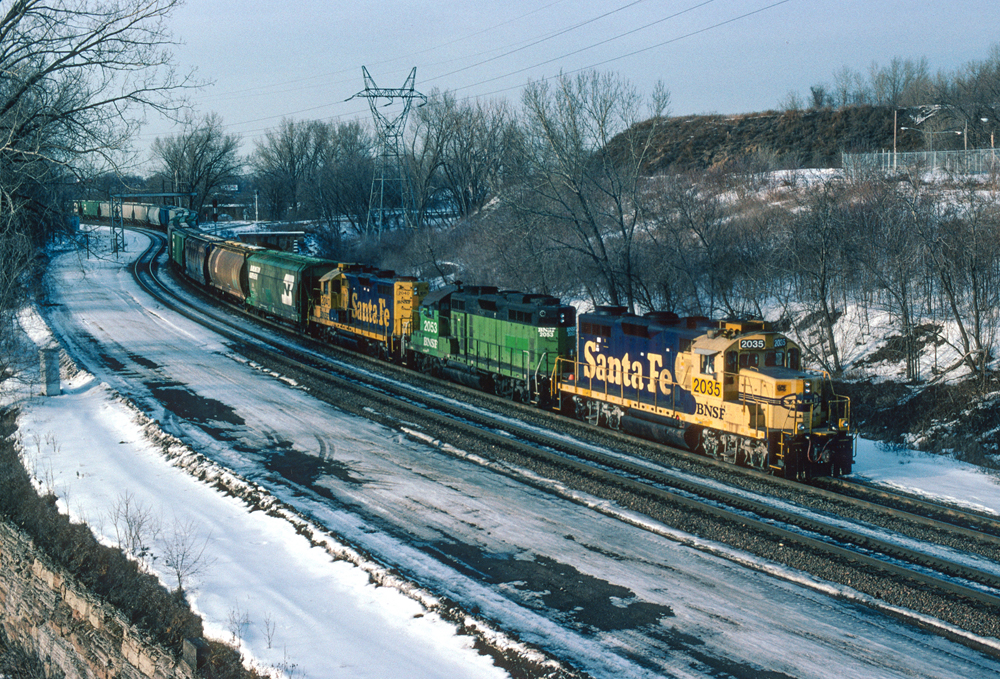 blue and yellow Santa Fe colored BNSF loaded grain train with green cars