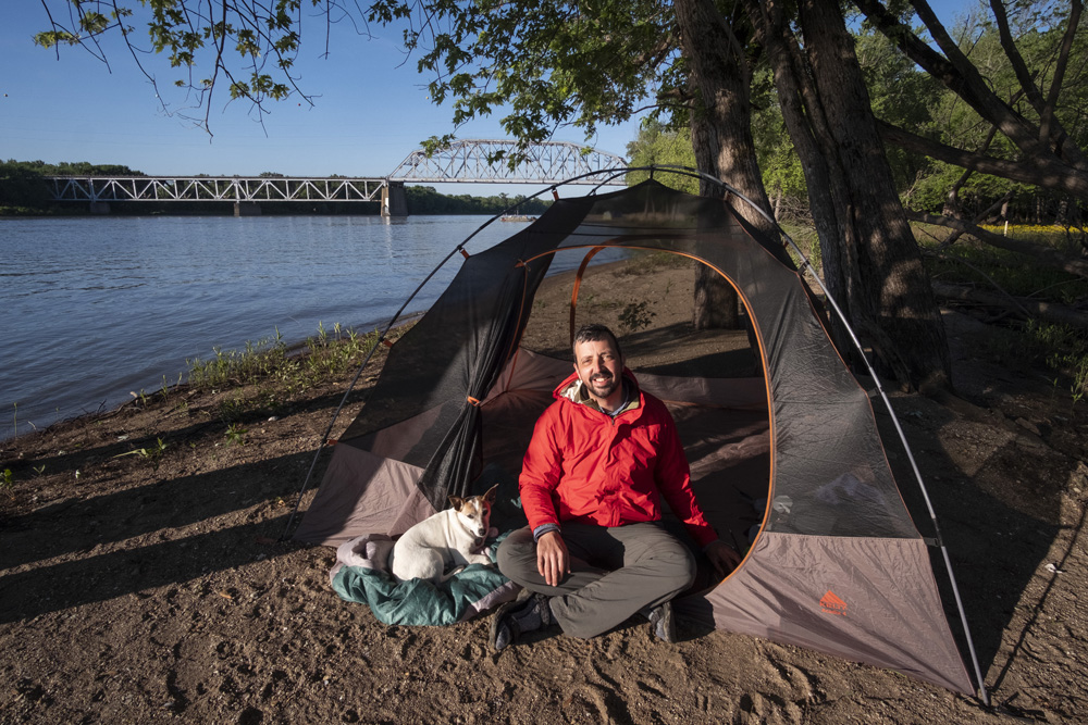 man in tent with dog