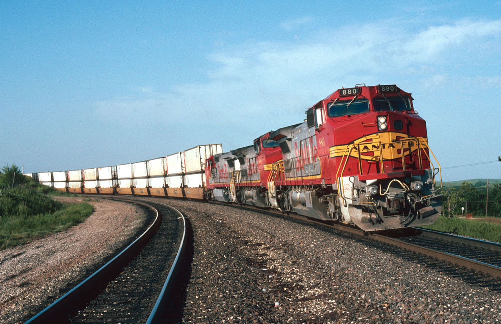 red and yellow locomotives with white intermodal containers