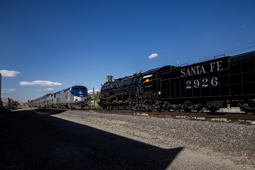 Steam locomotive meets with Amtrak passenger train. 