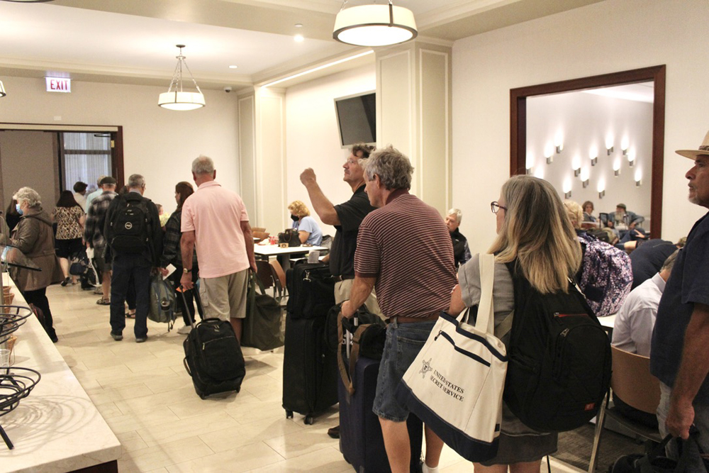 People in loosely organized line at railroad station