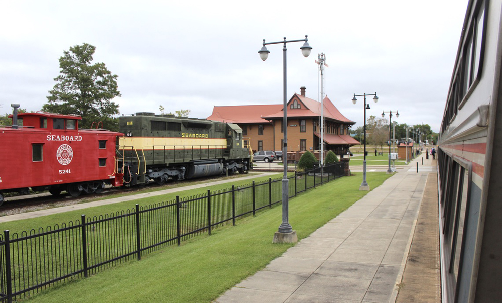 Locomotive and caboose on display next to passenger station