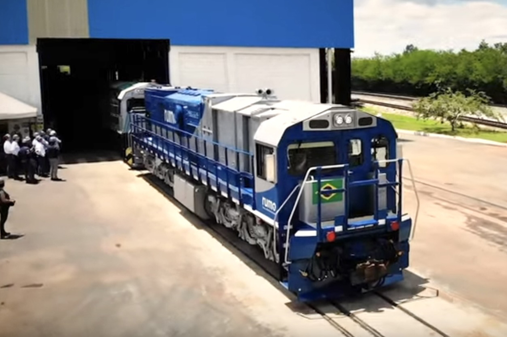 Blue and white locomotives exit building