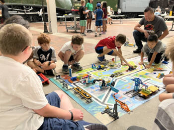 Group of children working a railroad robotics project.