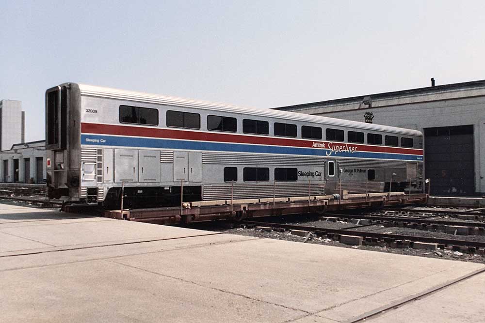 One of hundreds of Amtrak Superliner cars outside a building at the factory