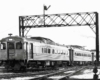 Self-propelled passenger rail cars under signal bridge