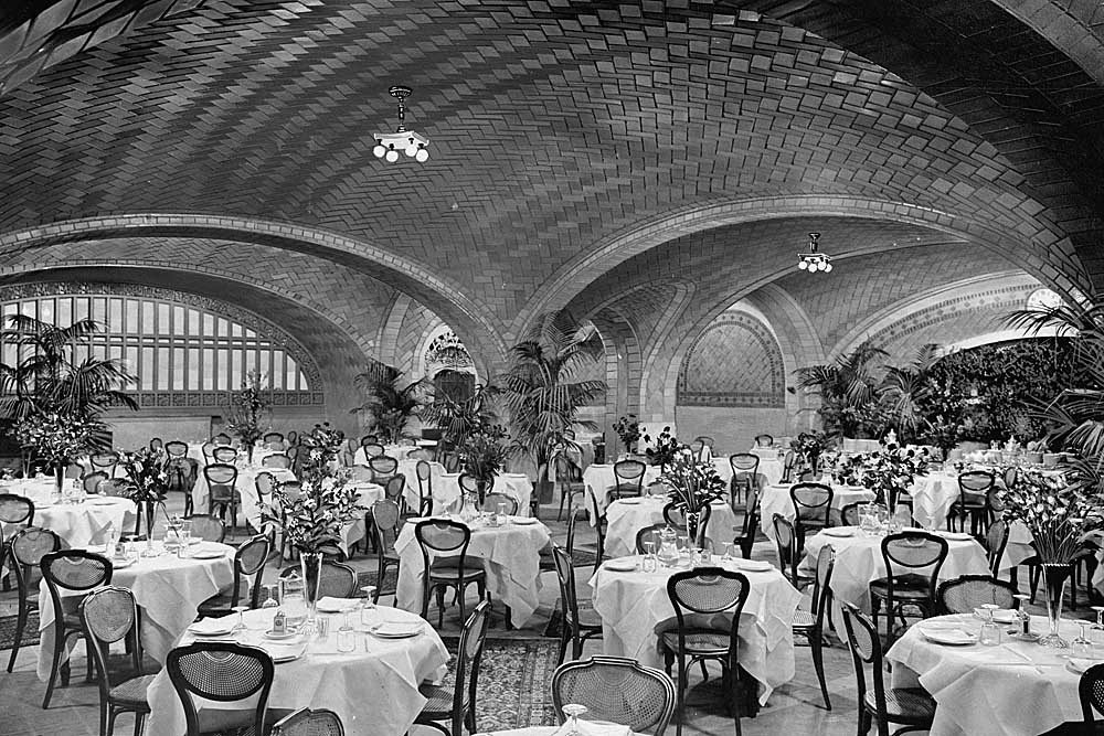 Interior of restaurant with no windows and white tablecloths under arched ceiling