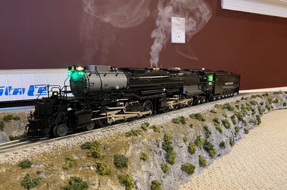 black steam locomotive model with lights and smoke