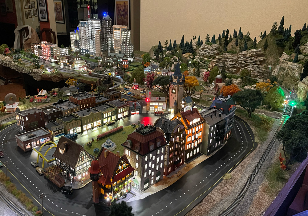 An overall view of the N scale layout, with a village in the foreground and city skyscrapers behind