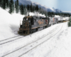 A trio of diesels pulls an intermodal freight train through a snowy mountain landscape