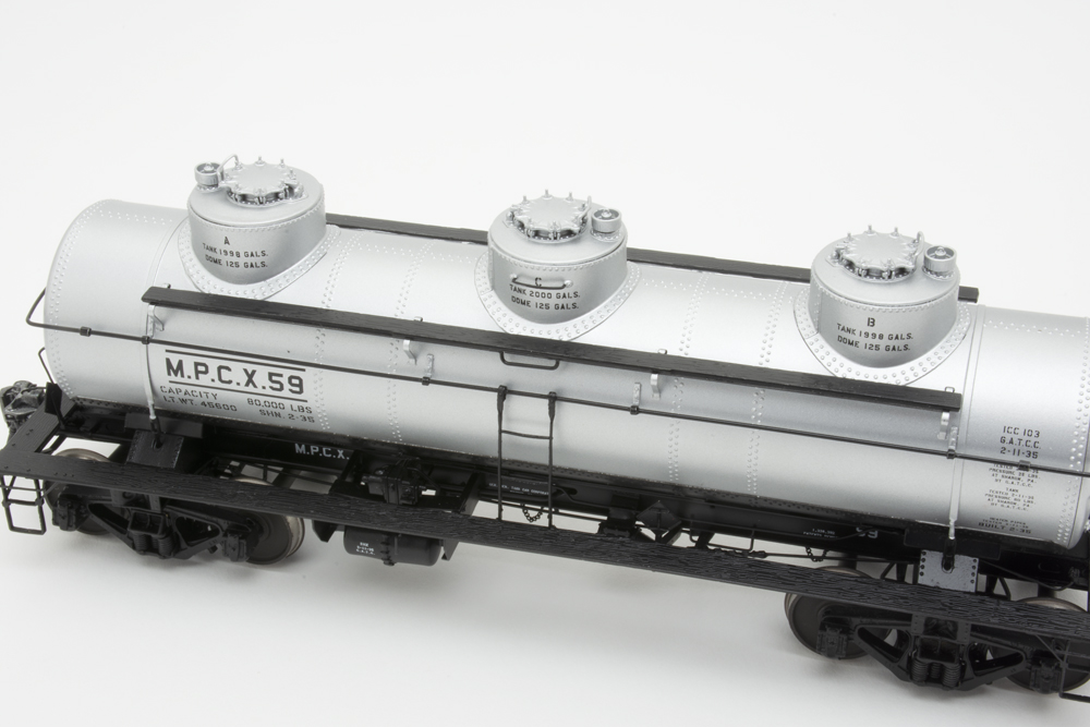 Close-up photo showing three domes on O scale tank car painted silver and black.