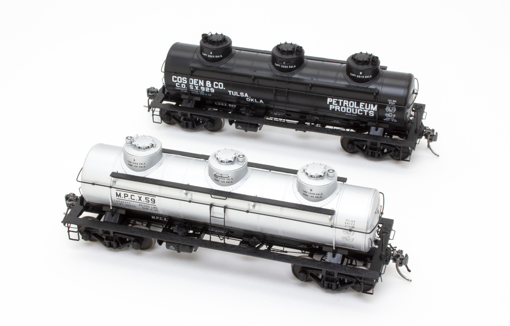 Photo showing two O scale three-dome tank cars.