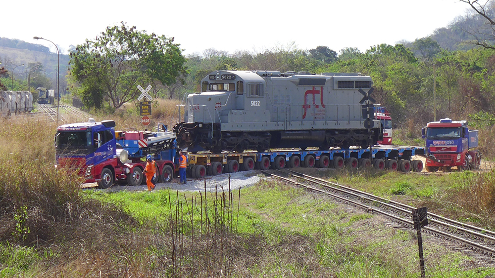 gray locomotive from different country being transported