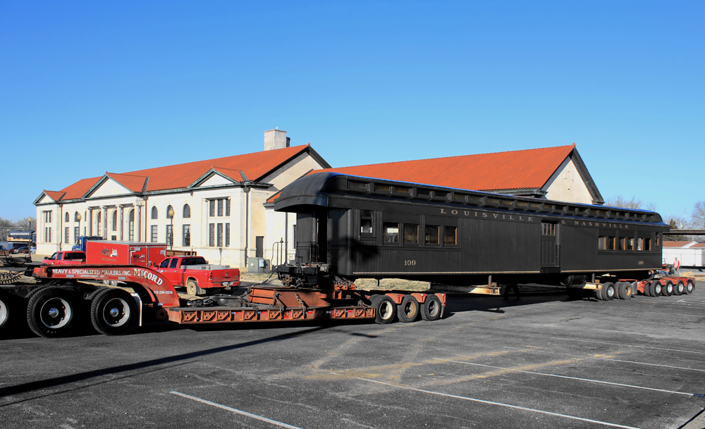 passenger car being moved by flat bed truck