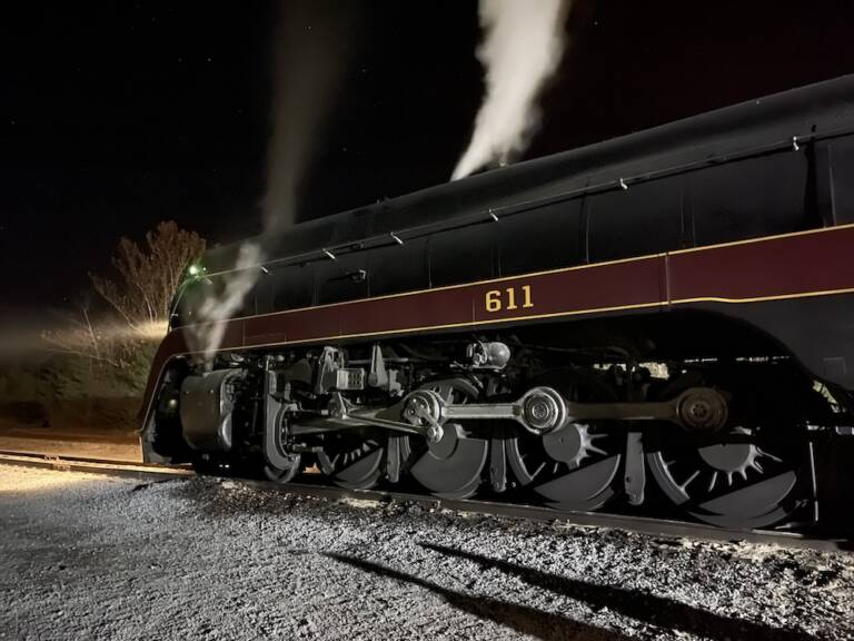 Streamlined steam locomotive sitting at night.