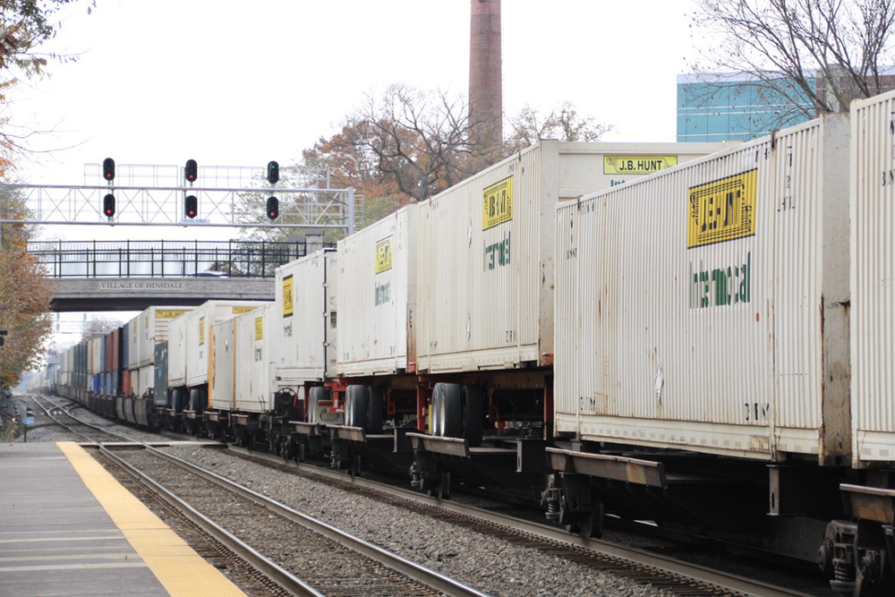 White intermodal containers and truck trailers on train