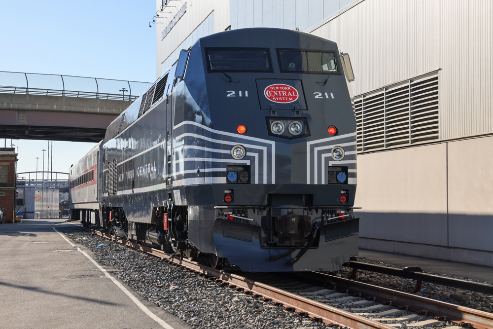 Front view of gray locomotive with white stripes