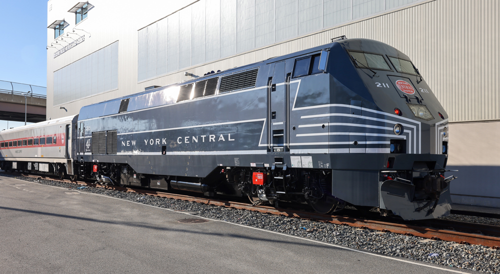 Three-quarters view of gray locomotive with white stripes