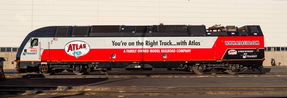 Side view of red, white, and black locomotive