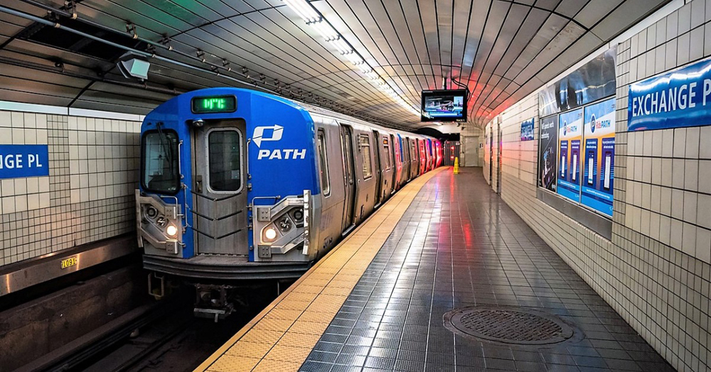 Silver subway trainset with blue front arrives at station