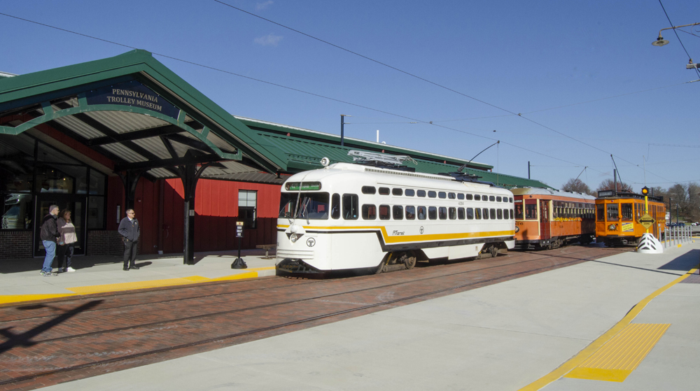 Three trolley cars in front of building