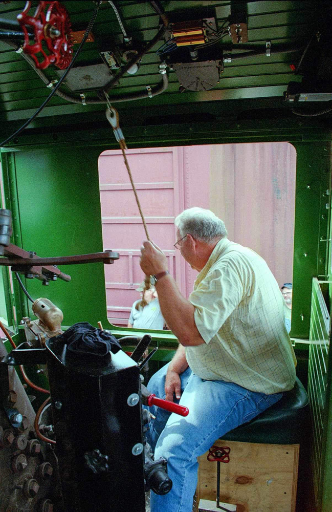 Man at throttle of steam locomotive