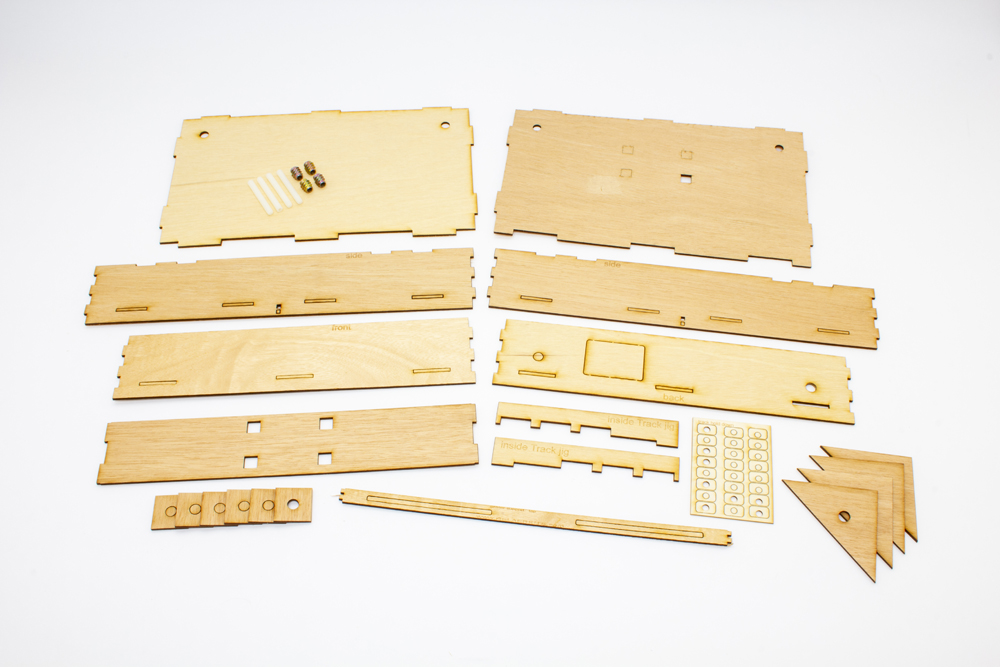 Bare wood laser-cut plywood parts arranged in two rows of rectangles.