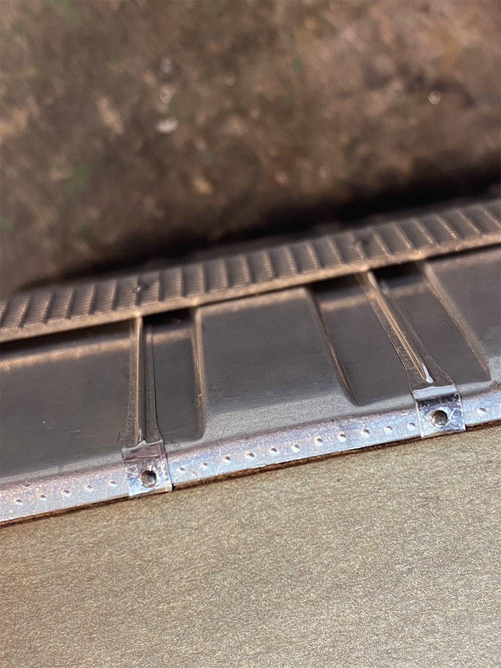 Build an O scale freight car: Silver corrugated metal with simulated rivet detail and raised metal ribs attached to wood model train boxcar with tiny metal nails.