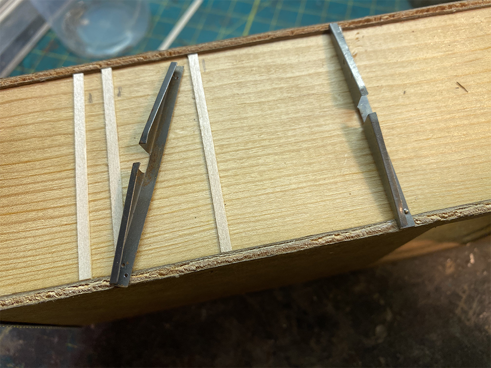 Build an O scale freight car: Brown wood rectangle with lighter-colored wood strips and long silver metal triangles.