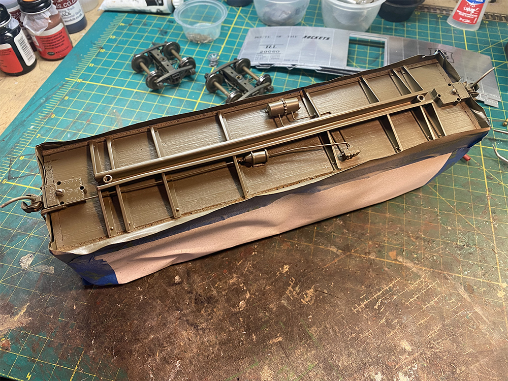 Model train boxcar floor with freshly painted brown-colored details.