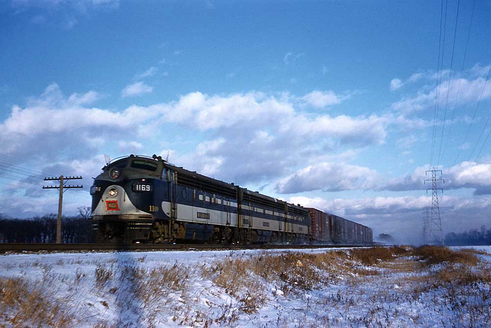 Blue-and-gray diesel locomotive on freight train of Wabash Railway history