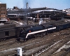 Blue-and-white steam Wabash locomotives with passenger train at curved-roof station