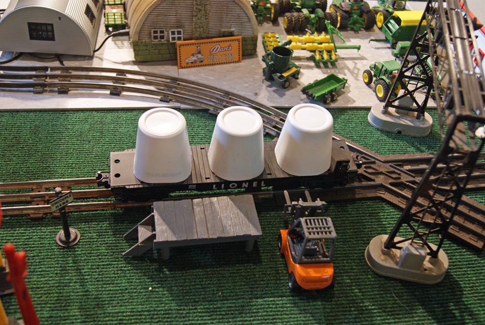 flatcar on layout with three white cups on top
