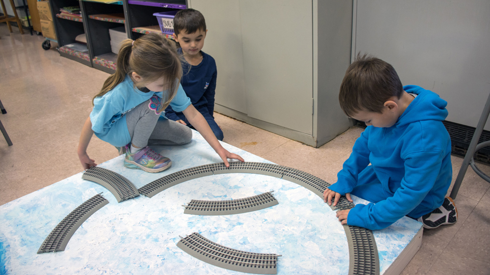 kids putting together sections of track