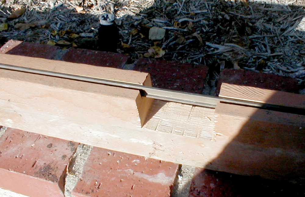 track rail resting in piece of cut wood