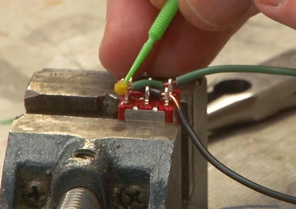 Photo showing flux being applied to solder lugs on a switch.
