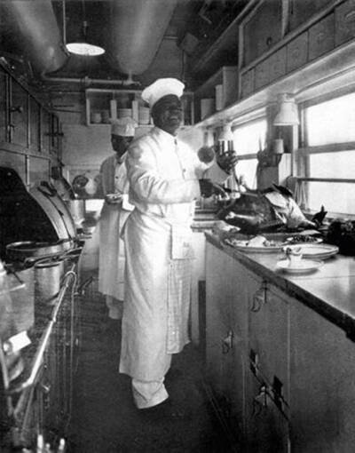 Chef carving a turkey in a dining car kitchen