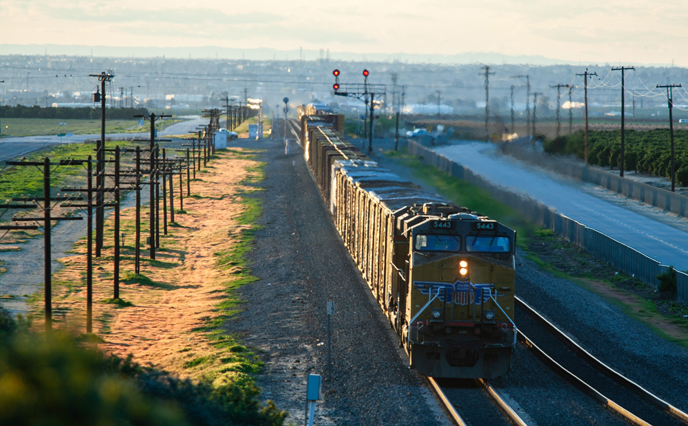 train on track with sun shining on one side