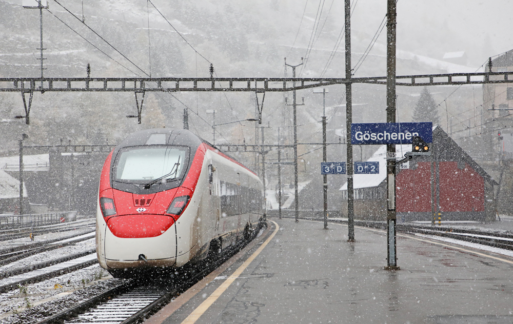Red-and-white high speed train in light snowfall