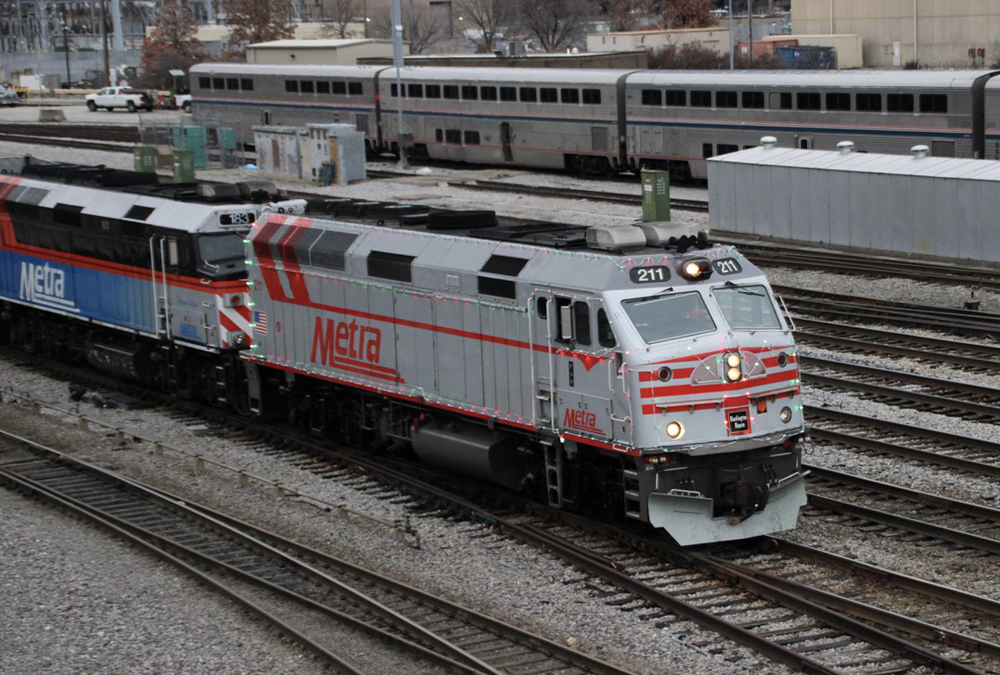 Silver and red locomotive with holiday lights