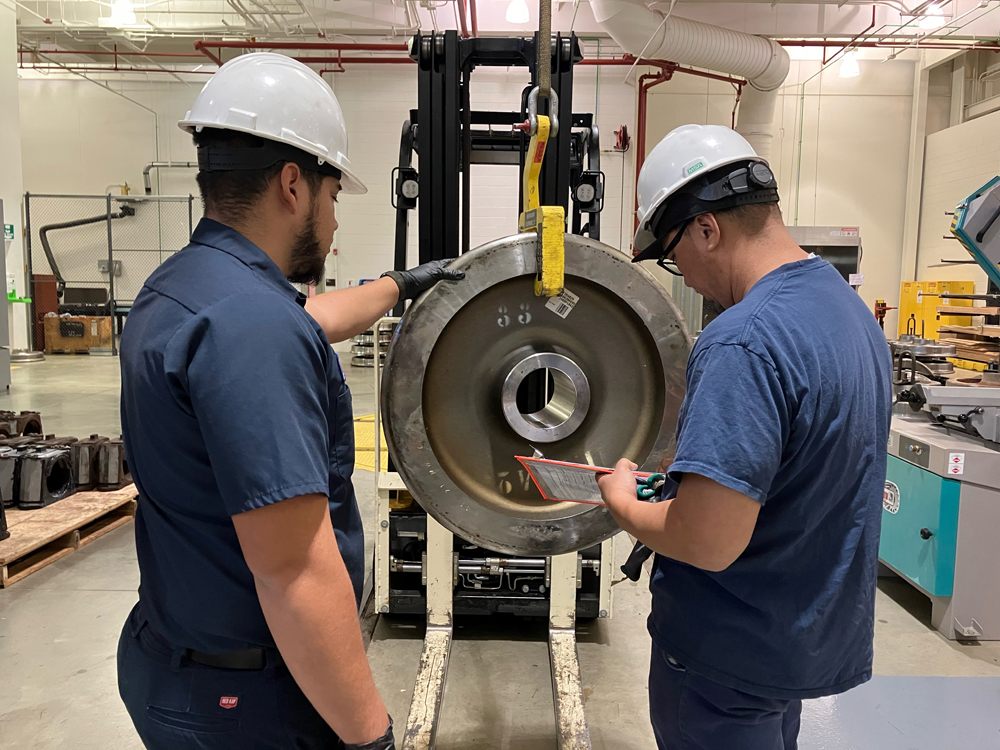 Two men with wheel for railcar