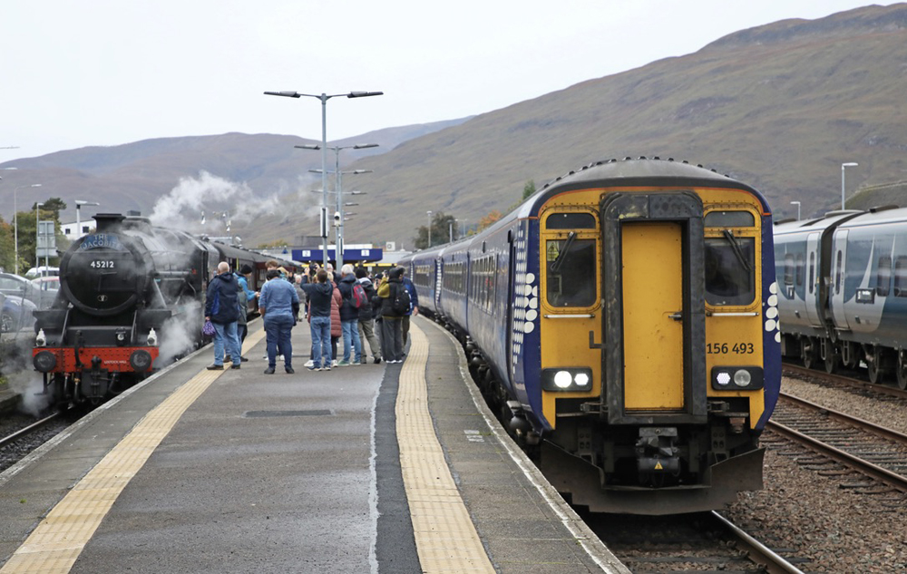 Steam and modern diesel passenger trains at station