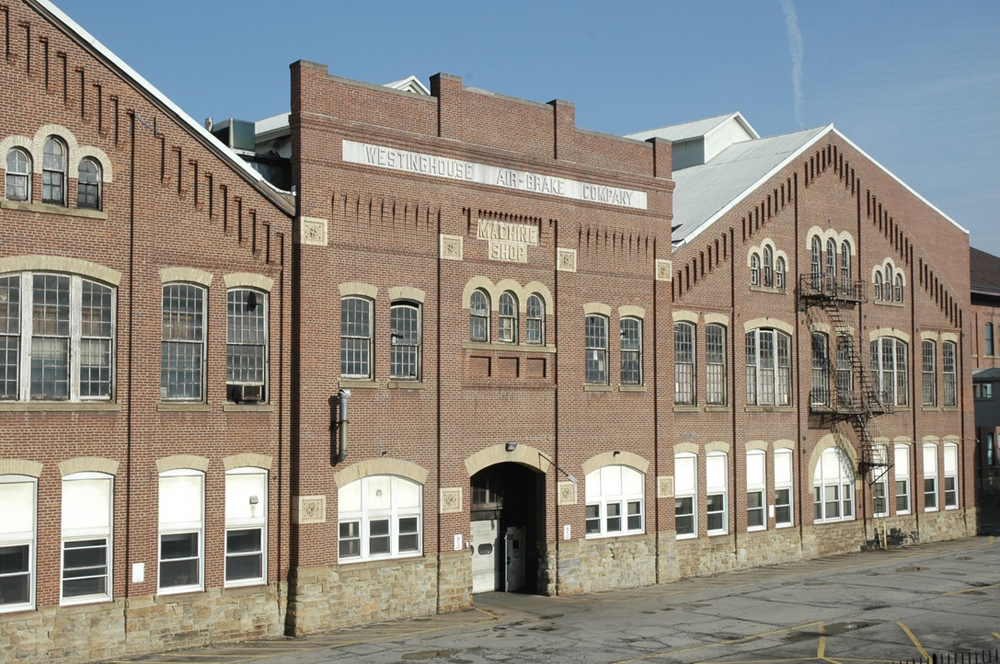 Large brick factory building with "Westinghouse Air Brake" sign built into the structure