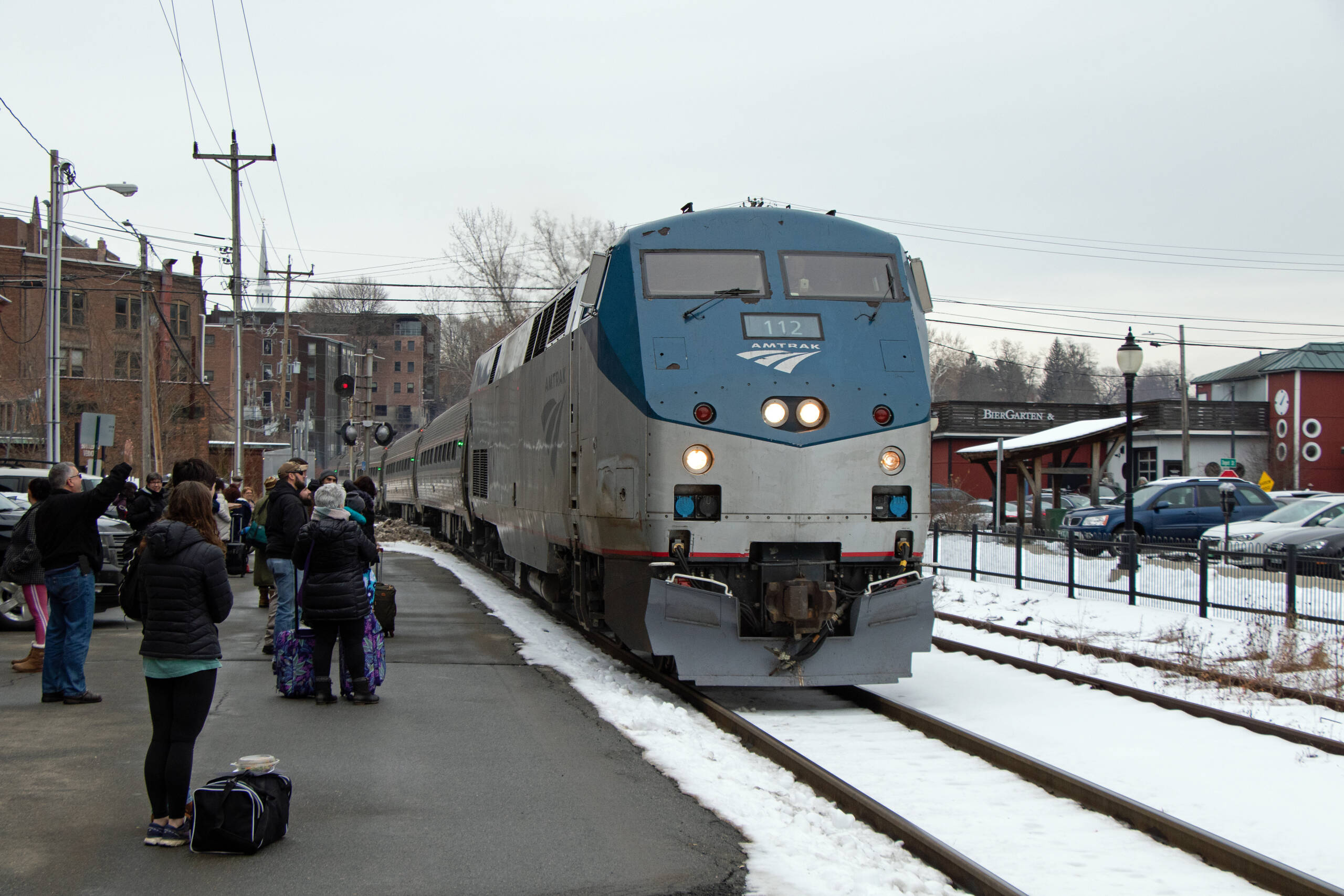 Blue and gray diesel locomotive and passenger train at station platform
