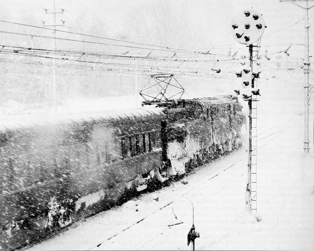 Blizzard around passenger train with electric locomotive